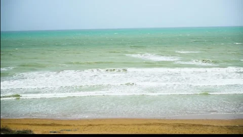 Static slow motion shot of the ocean with calm waves reaching the shore of a Stock Footage 284445327