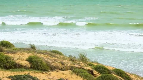 Static slow motion shot of the ocean with calm waves reaching the shore of a Stock Footage 284445330