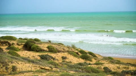 Static slow motion shot of the ocean with calm waves reaching the shore of a Stock Footage 284445412