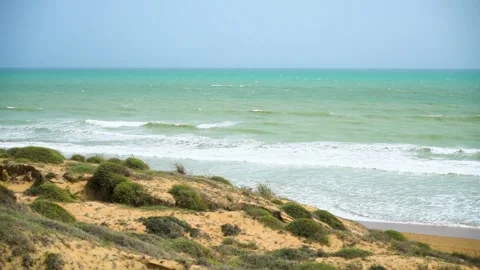 Static slow motion shot of the ocean with calm waves reaching the shore of a Stock Footage 284445494