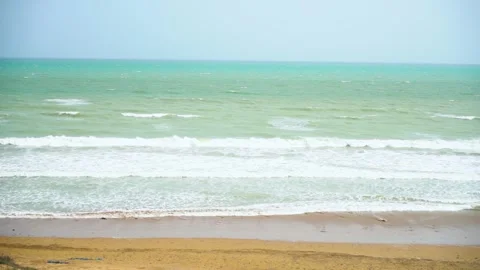 Static slow motion shot of the ocean with calm waves reaching the shore of a Stock Footage 284445598
