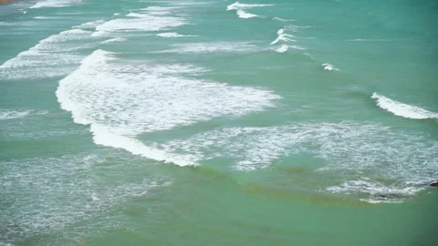 Static slow motion shot of the ocean with calm waves reaching the shore of a Stock Footage 284445662