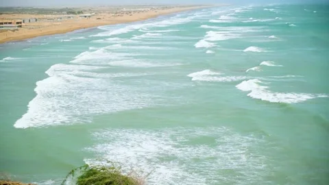 Static slow motion shot of the ocean with calm waves reaching the shore of a Stock Footage 284445669