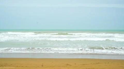 Static slow motion shot of the ocean with calm waves reaching the shore of a Stock Footage 284445834