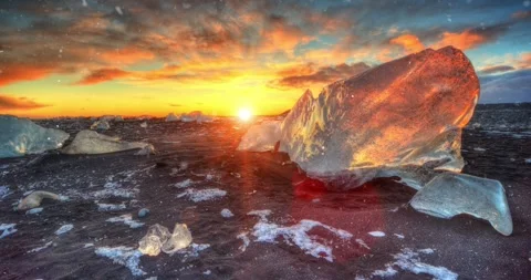 Static slow motion shot of sunset at Diamond Beach in Iceland with falling snow. Stock Footage 324047156