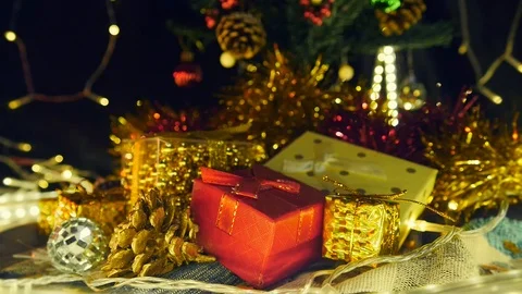 Static, stack of gift boxes under Christmas tree with lights flashing in Stock Footage 121715705