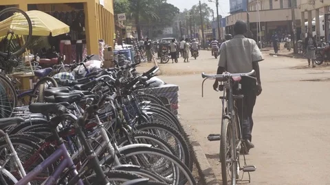 Static tight shot of bicycles next to busy Ugandan street Video stock 81749113