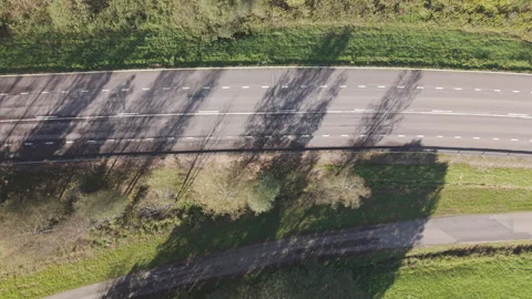 Static top down aerial drone view of country road and passing car in Sweden Stock Footage 323862918
