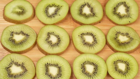 Static Top Down Shot of Kiwi Slices Pattern on Wooden Board Stock Footage 319916067