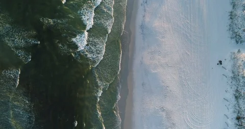 Static top down view of couple sat on beach with waves crashing drone aerial 4K Stock Footage 111415502