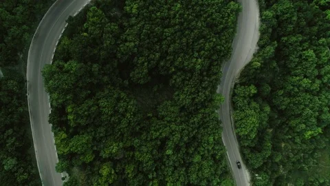 Static top view aerial shot traffic on winding asphalt roads surrounded by hilly Stock Footage 97645209