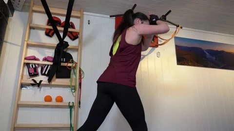 Static upper body profile shot of female doing squats with jumps in a tiny 스톡 동영상 153263066