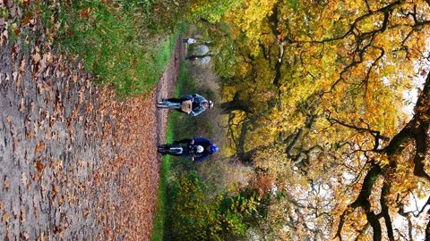 A static, vertical / 9:16 shot of cyclists on a rural cycle path path Stock Footage 143013721