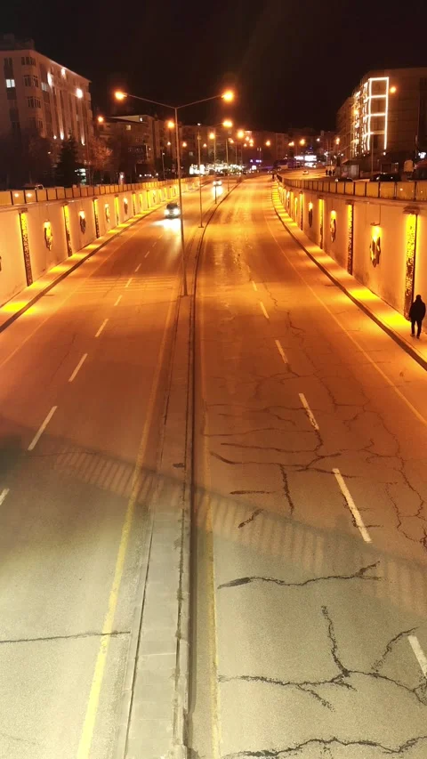 Static vertical night shot of a city highway with cars driving through an Vídeos de archivo 333605965