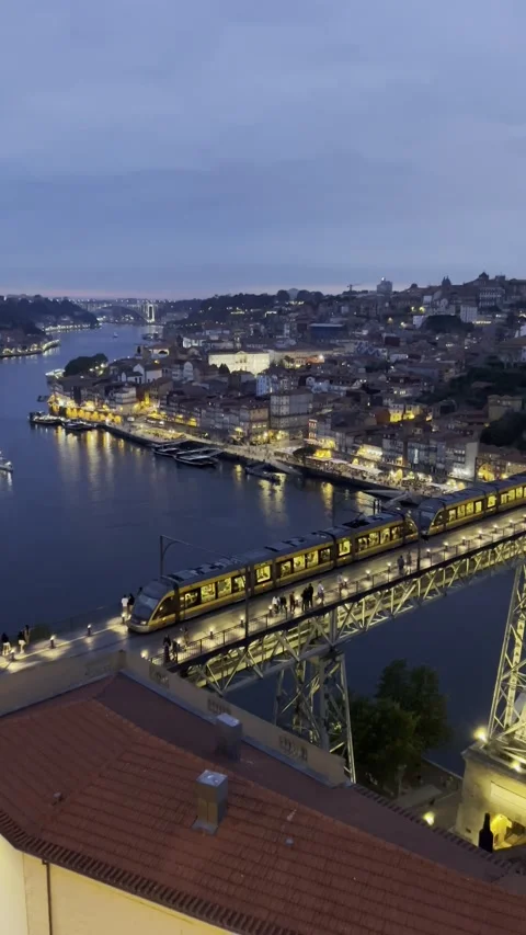 Static vertical night shot of train crossing the illuminated bridge in Porto Video stock 310617578