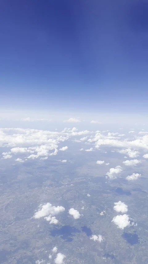 Static vertical shot of cirrus clouds in a bright blue sky from a flight window Stock Footage 336506618