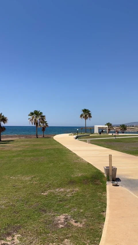 Static vertical shot of a concrete pedestrian path stretching towards the coast Video stock 336320475