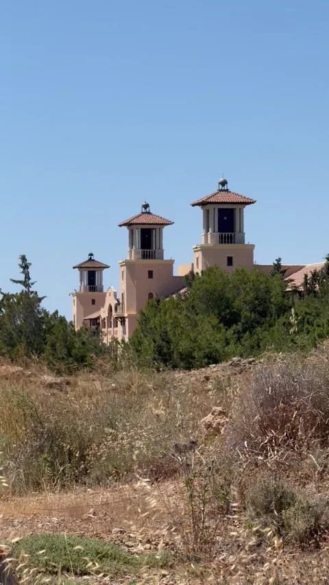 Static vertical shot of modern mediterranean resort towers overlooking nature Stock Footage 336320574