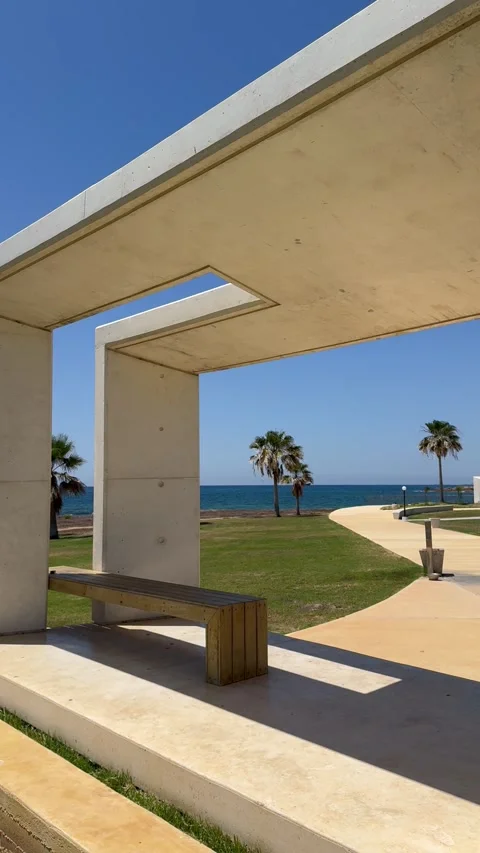 Static vertical shot of modern white concrete arch overlooking the sea Stock Footage 336320473