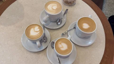 Static vertical top view of four cups of cappuccino coffee on cafe table Stock Footage 336660087