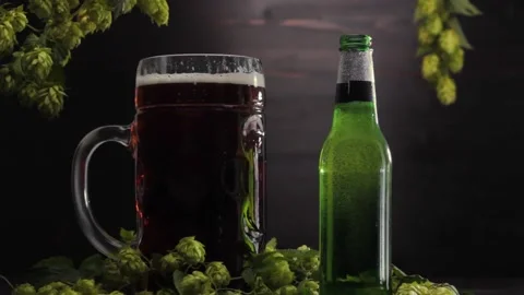 Static video with a bottle and a beer glass on a wooden background with hops Stock Footage 221546266