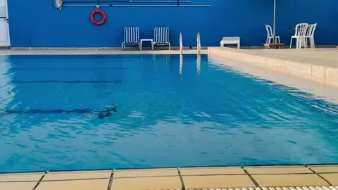 Static video of clear blue swimming pool with tiled deck Stock Footage 317542464