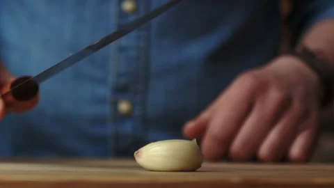 Static video of crushing garlic with a kitchen knife Stock Footage 131589375