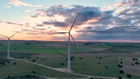 Static video from a drone of a wind turbine operating against the sunset Stock Footage 274528273