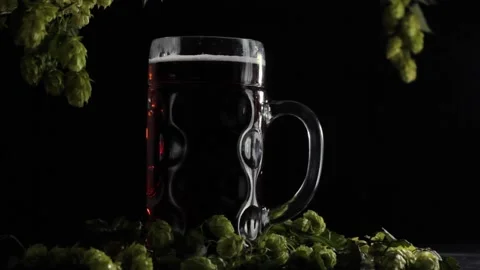 Static video frame with a full beer glass on a wooden background with hops Stock Footage 221547096