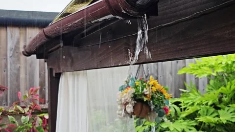 Static video of a leaking rain gutter overflowing with water on a cozy summer Stock Footage 336265289