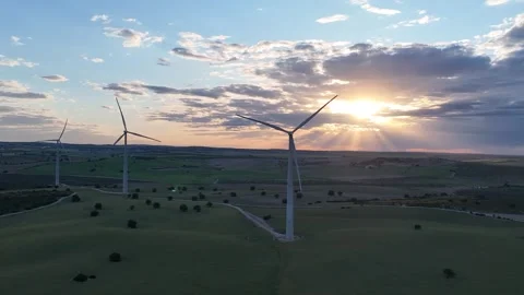 Static video of moving wind turbines with the sun setting between clouds Stock Footage 274193035