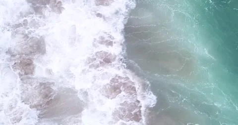 Static video in overhead shot of ocean waves breaking on a beach shore Stock Footage 310296691