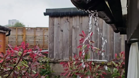 Static video of rainwater pouring from a broken rain gutter joint during a Stock Footage 336265151