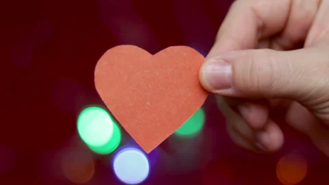 Static video of a red or orange (light brown) paper heart holded by a girl hand 스톡 동영상 167913840