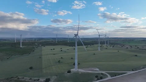 Static video of wind turbines rotating in the wind over green fields Stock Footage 274193984