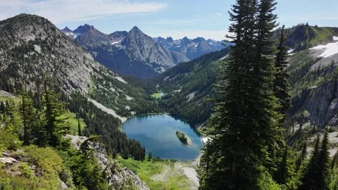 Static view of an alpine lake in a mountain valley surrounded by forest Stock Footage 342076340