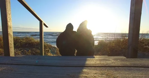 Static view from behind to a couple sitting on the steps - 002 Vídeo Stock 128576899