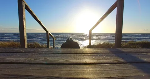Static view from behind to a couple sitting on the steps - 001 Stock-Footage 128576900