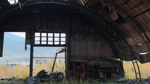 Static view of a dilapidated arched industrial building with exposed wooden Stock Footage 345931732