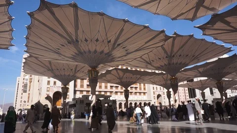 Static view of exterior of Nabawi mosque court yard with pilgrims in Medina Stock Footage 122809669