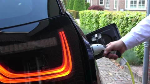 Static view of man unplugging electric vehicle 4k Stock Footage 147552198
