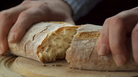 Static view of mans hands tearing loaf of bread in half Stock Footage