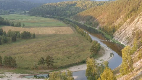 Static view from a mountain to a slow river, haystacks and pine forest 動画素材 83994821