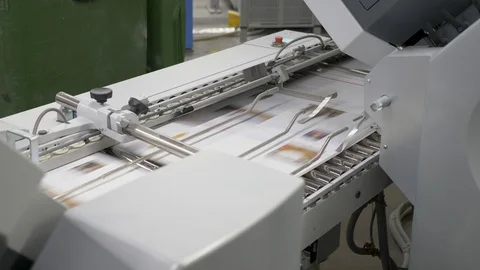 A static view of numerous sheets of printed papers moving through rollers Stock Footage 117292446