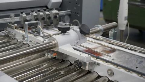 A static view of numerous sheets of printed papers moving through rollers Stock Footage 117292449