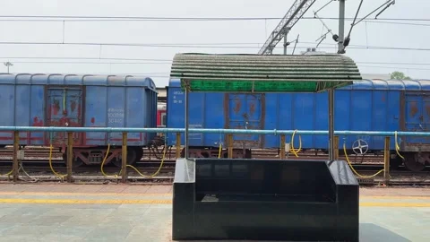 Static view from a railway platform as a blue freight train passes through Stock Footage 340975530