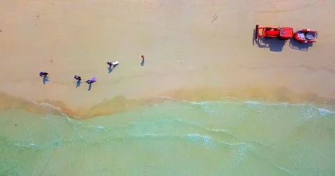Static view of red tractor with people cleaning a tropical beach Stock Footage 88720819