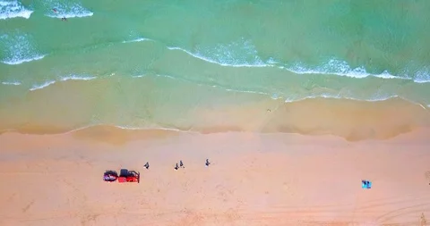 Static view of red tractor with people cleaning a tropical beach Stock Footage 88720914