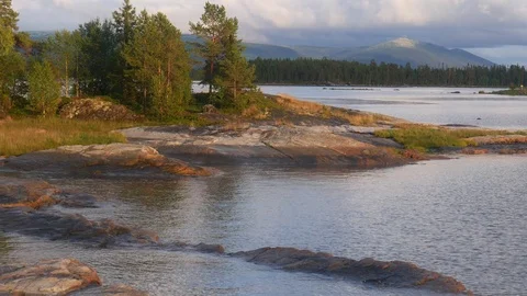Static view to sea shore, pine forest and mountains. Cloads are moving. Stock Footage 84077133