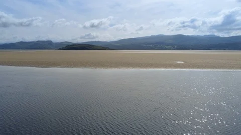 Static view on slowly moving water, sea, sand and island in Snowdonia mountai Stock Footage 94234084